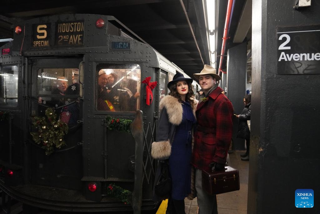 People in vintage clothing pose in front of the Holiday Nostalgia Train in New York City, the United States, on Dec. 14, 2025.
Holiday Nostalgia Train, vintage 1930s train cars, is running every Sunday in December to celebrate the holiday season here in New York, taking passengers to step back in time. (Xinhua/Zhang Fengguo)