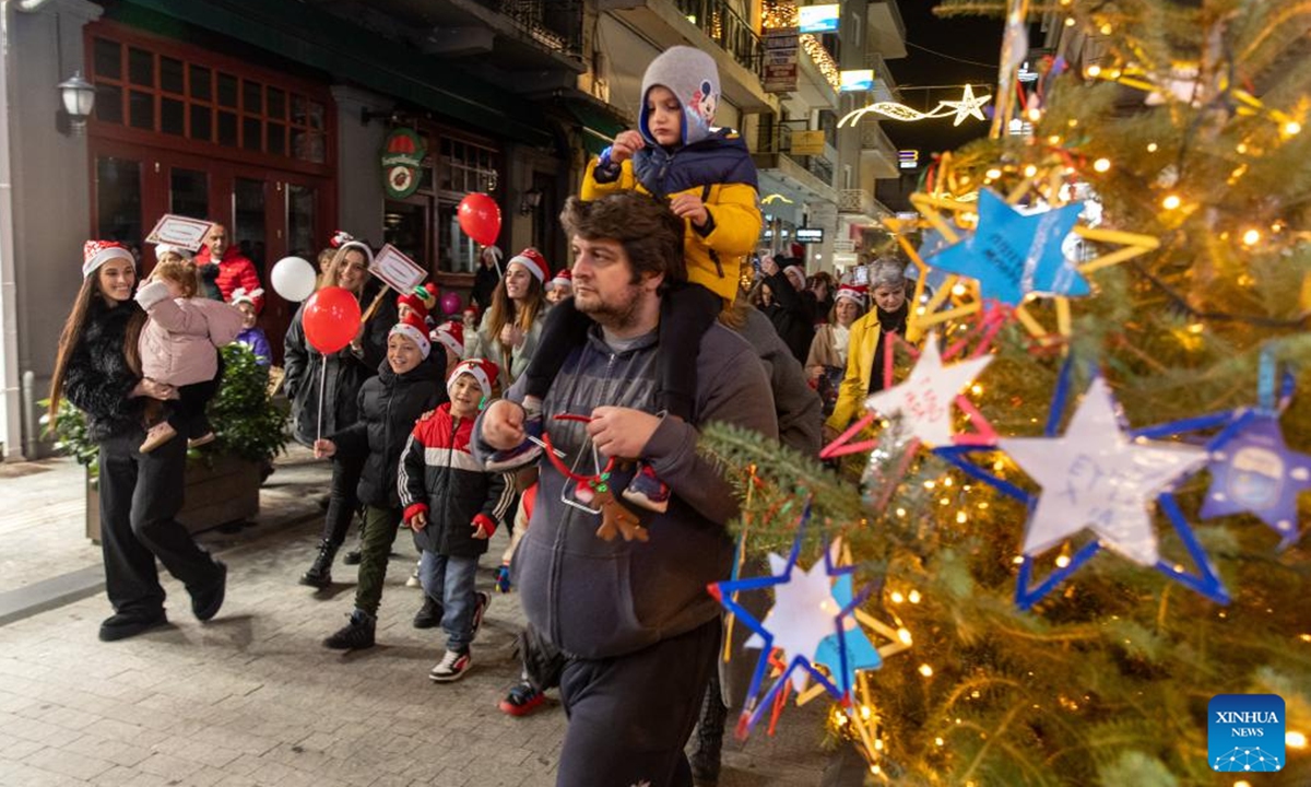 People celebrate the Christmas season at Areos Square in Tripoli, Greece, Dec. 14, 2025.
Tripoli, a city at the heart of the Peloponnese peninsula in southern Greece, was filled with festive colors and music on Sunday evening as it hosted its Santa Walk for the third consecutive year.
Around 600 people of all ages dressed in Santa Claus costumes took part in the event, spreading Christmas cheer through the streets before gathering in the city's central square for the lighting of the municipal Christmas tree. (Photo by Marios Lolos/Xinhua)