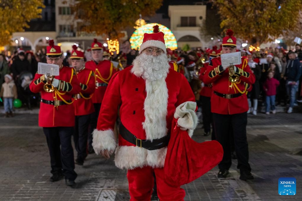 People celebrate the Christmas season at Areos Square in Tripoli, Greece, Dec. 14, 2025.
Tripoli, a city at the heart of the Peloponnese peninsula in southern Greece, was filled with festive colors and music on Sunday evening as it hosted its Santa Walk for the third consecutive year.
Around 600 people of all ages dressed in Santa Claus costumes took part in the event, spreading Christmas cheer through the streets before gathering in the city's central square for the lighting of the municipal Christmas tree. (Photo by Marios Lolos/Xinhua)