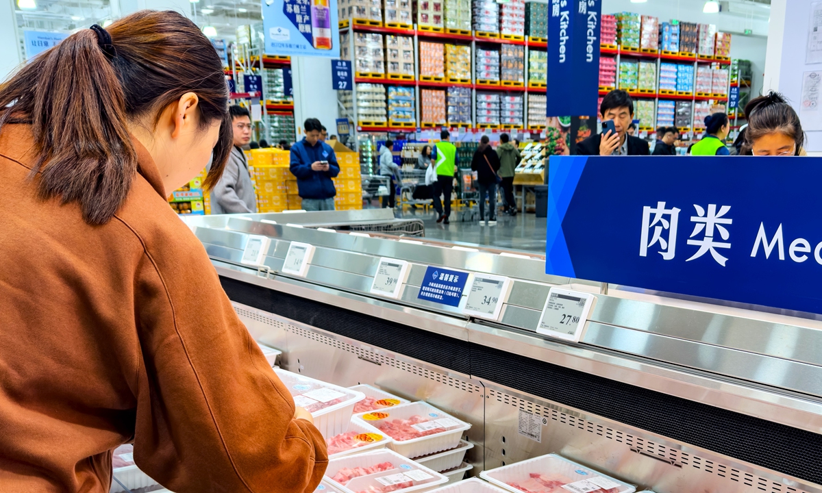 A customer selects pork products at a refrigerated display at a Sam's Club store in Yangzhou, East China's Jiangsu Province, on November 13, 2025. The store officially opened on November 12. Photo: VCG