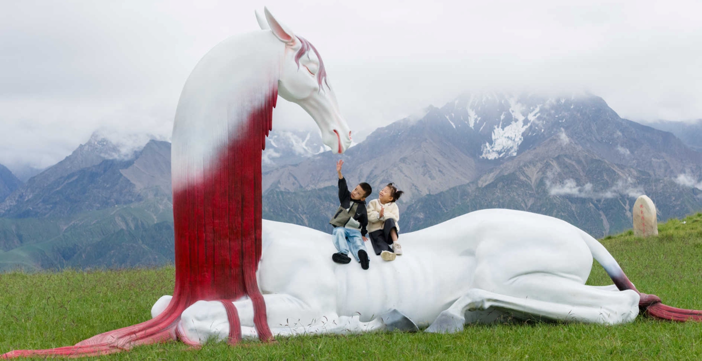 Children play on a sculpture of the mythical beast Jiliang, a divine horse mentioned in the <em>Shan Hai Jing</em>, by Qiu Qijing on display at an exhibition on the Kunlun Mountains  Photo: Courtesy of Qiu Qijing