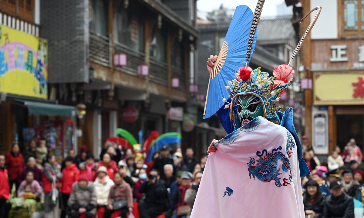 A Sichuan Opera performer showcases traditional face-changing and fire-spitting for the public in Neijiang, Southwest China's Sichuan Province, on December 16, 2025. As part of the city's public welfare tour, the event aims to bring traditional Sichuan Opera to people's doorsteps, enriching their cultural lives. Photo: VCG
