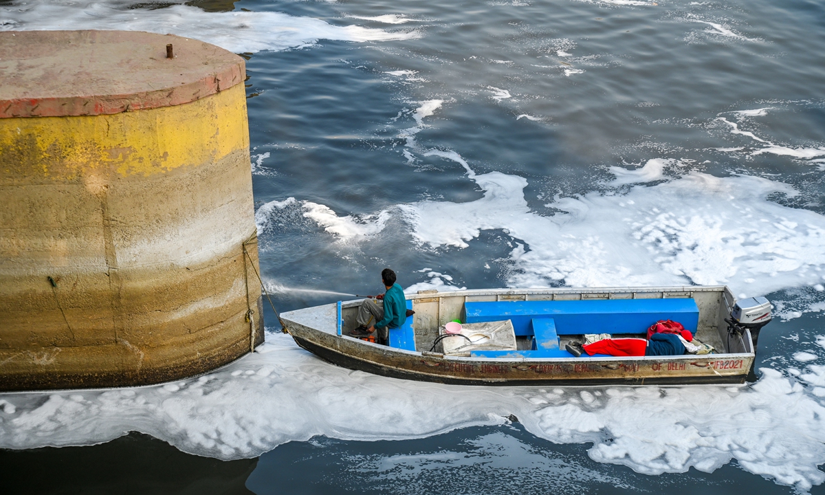 A worker from the Delhi Jal Board, the Indian capital's water company, sprays anti-surfactant solution to dissolve toxic foam at the Kalindi Kunj Yamuna River on December 16, 2025 in New Delhi, India. The Yamuna River suffers high levels of pollution. Photo: VCG