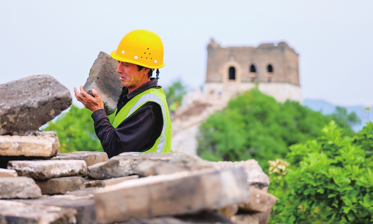Yu Xilin, a worker carries bricks at the Zhengbeilou section of the Great Wall in Beijing, on July 4, 2024. 