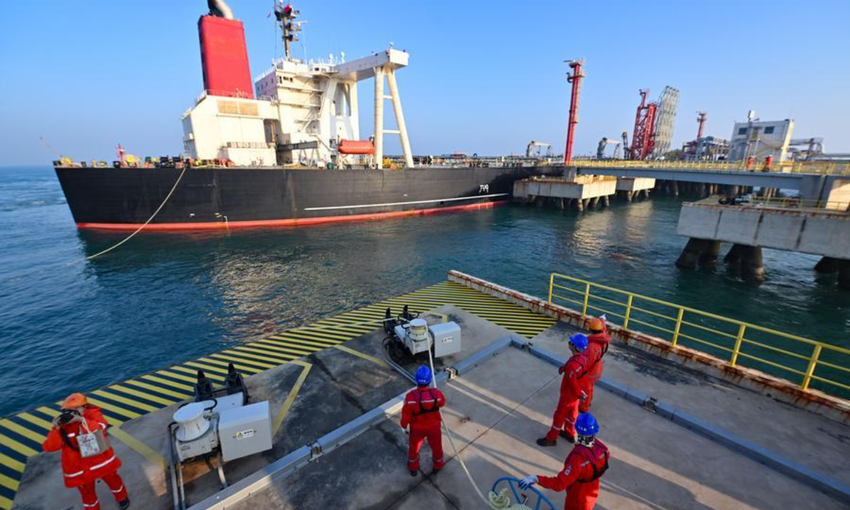 Staff members tie a mooring rope for a vessel carrying petrochemical raw materials at Yangpu Port in Danzhou, south China's Hainan Province, Dec. 18, 2025. (Xinhua/Guo Cheng)