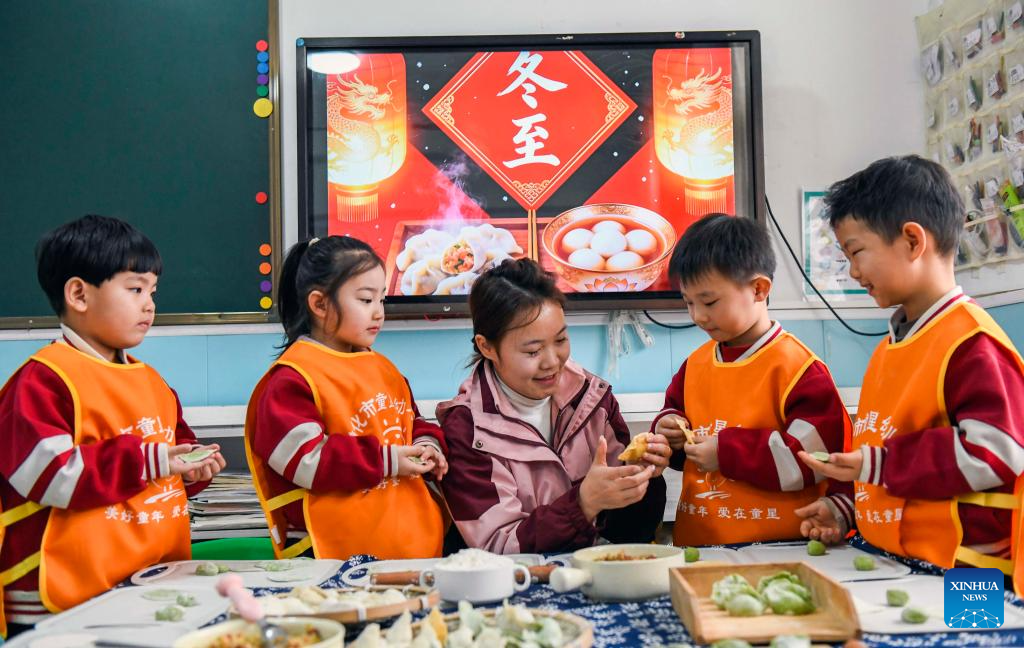 A teacher teaches children to make dumplings at a kindergarten in Zunhua City, north China's Hebei Province, Dec. 19, 2025. Winter Solstice, the shortest day of the year, which will fall on Dec. 21 this year, denotes the beginning of deep winter and a break from farming in traditional agricultural society in Chinese culture. Northern China has maintained the tradition of eating dumplings on this day, while people in southern China eat tangyuan (glutinous rice balls). (Photo by Liu Mancang/Xinhua)