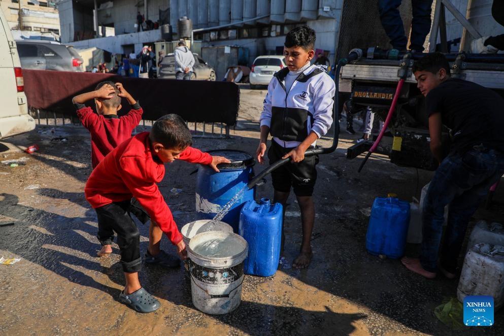 Palestinian children transport water with containers in Gaza City, Dec. 18, 2025. (Photo by Rizek Abdeljawad/Xinhua)