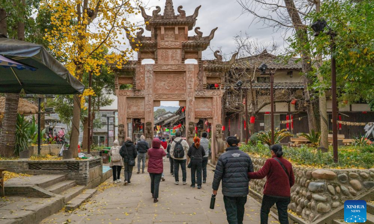 Tourists visit Zhaohua ancient town in Zhaohua District of Guangyuan City, southwest China's Sichuan Province, Dec. 12, 2025. Zhaohua ancient town, located in Guangyuan City of southwest China's Sichuan Province, sits at the confluence of the Bailong River, the Jialing River, and the Qingjiang River. As a well-preserved ancient town, it carries a history of over 2,300 years. However, due to old infrastructure and unplanned construction, the ancient town once fell into disorder with residents living in the town having to undergo various difficulties. In order to refresh the ancient town, since 2012, Zhaohua District has launched a project to preserve the villages as a whole. While improving the village environment, the preservation project brings along local rural tourism, allowing the ancient town to be revitalized through preservation. (Photo by Wang Jun/Xinhua)