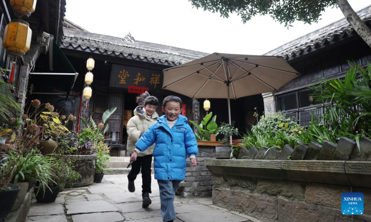 Kids play in a family inn in Zhaohua ancient town in Zhaohua District of Guangyuan City, southwest China's Sichuan Province, Dec. 13, 2025. Zhaohua ancient town, located in Guangyuan City of southwest China's Sichuan Province, sits at the confluence of the Bailong River, the Jialing River, and the Qingjiang River. As a well-preserved ancient town, it carries a history of over 2,300 years. However, due to old infrastructure and unplanned construction, the ancient town once fell into disorder with residents living in the town having to undergo various difficulties. In order to refresh the ancient town, since 2012, Zhaohua District has launched a project to preserve the villages as a whole. While improving the village environment, the preservation project brings along local rural tourism, allowing the ancient town to be revitalized through preservation. (Xinhua/Chen Bin)