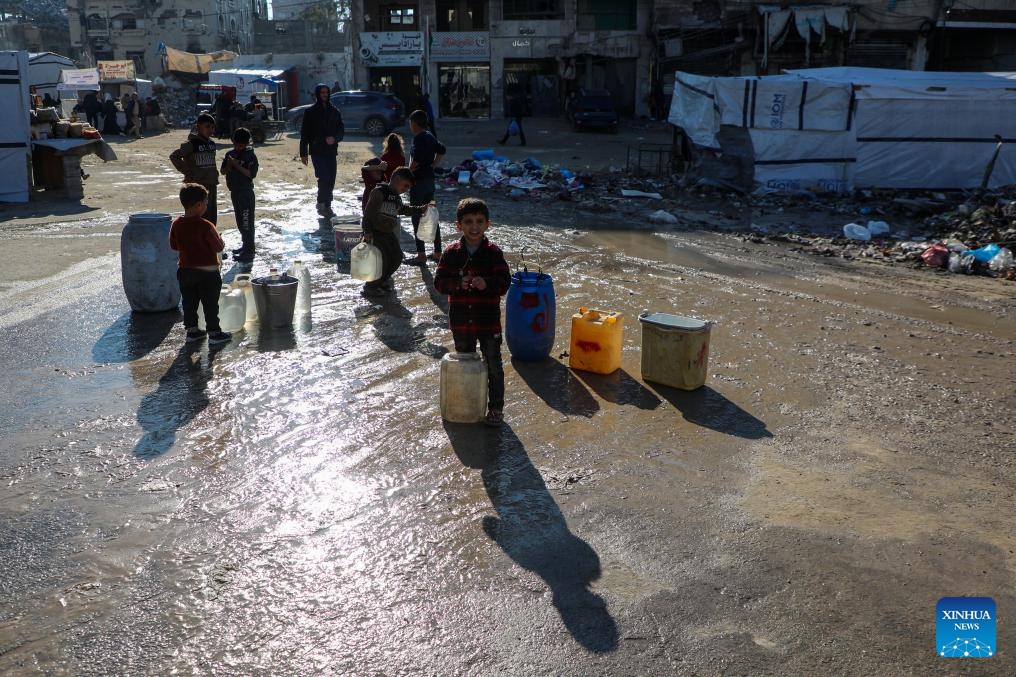 Palestinian children transport water with containers in Gaza City, Dec. 18, 2025. (Photo by Rizek Abdeljawad/Xinhua)