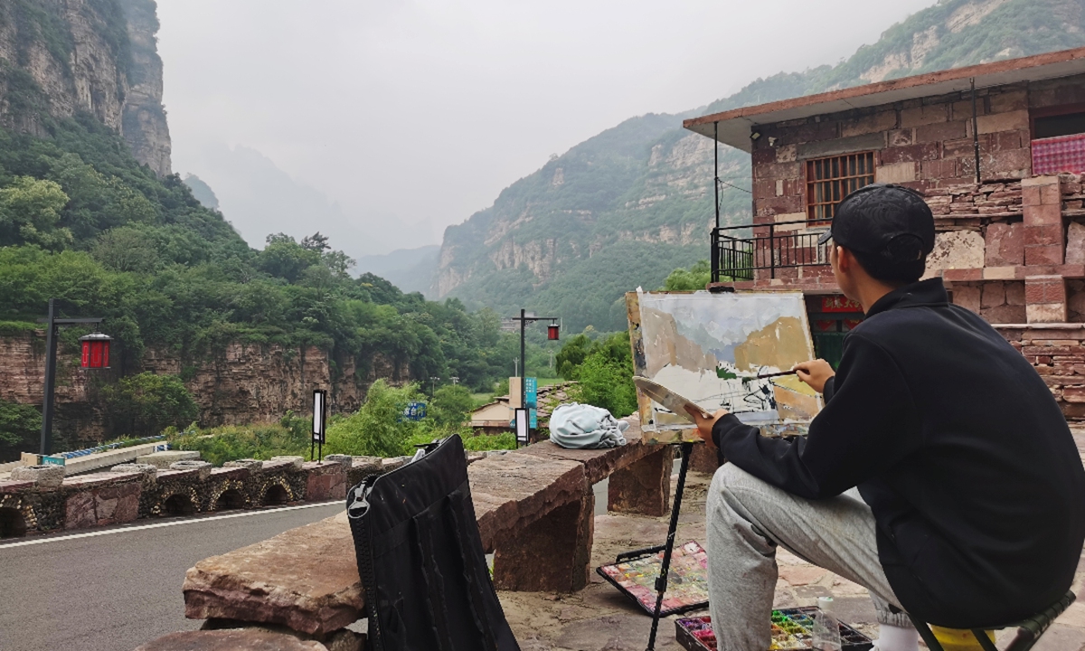 An artist paints a picture in Shibanyan town, Anyang, Central China's Henan Province. Photo: VCG 