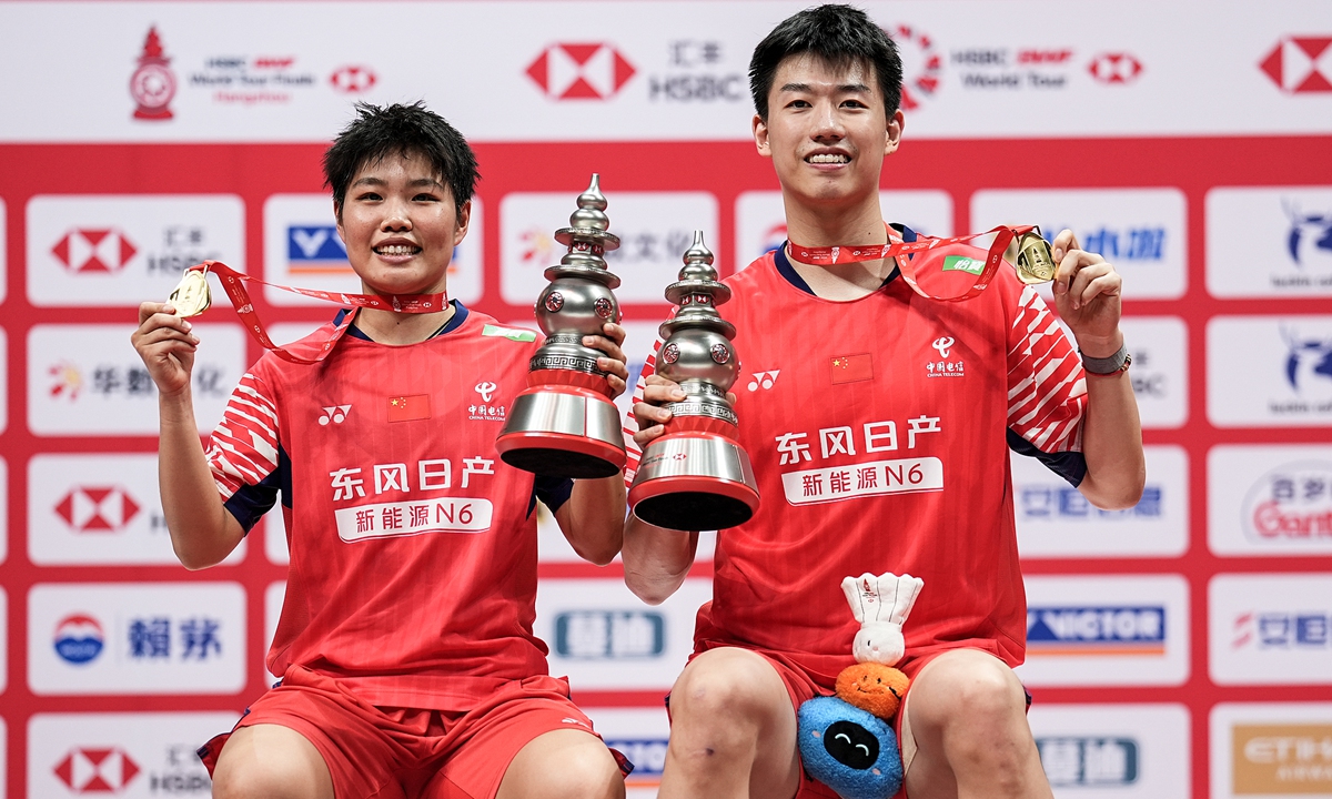 Feng Yanzhe (R) and Huang Dongping of China pose with their trophies on the podium after the Mixed Doubles Final match against Jiang Zhenbang and Wei Yaxin of China during day five of the BWF World Tour Finals 2025 at Hangzhou Olympic Sports Centre Stadium on December 21, 2025 in Hangzhou, East China's Zhejiang Province. Photo: VCG
