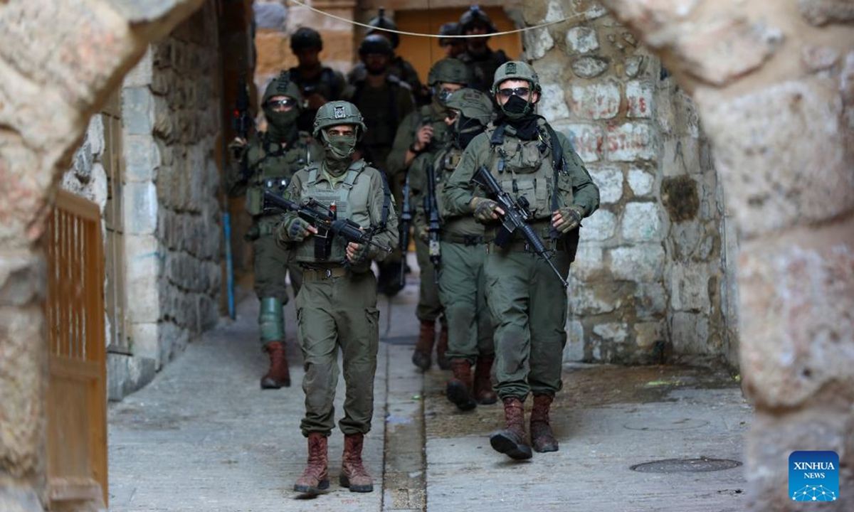 Members of Israeli forces secure the streets for Israeli settlers in the Old City of Hebron in the southern West Bank, on Dec. 20, 2025. (Photo by Mamoun Wazwaz/Xinhua)