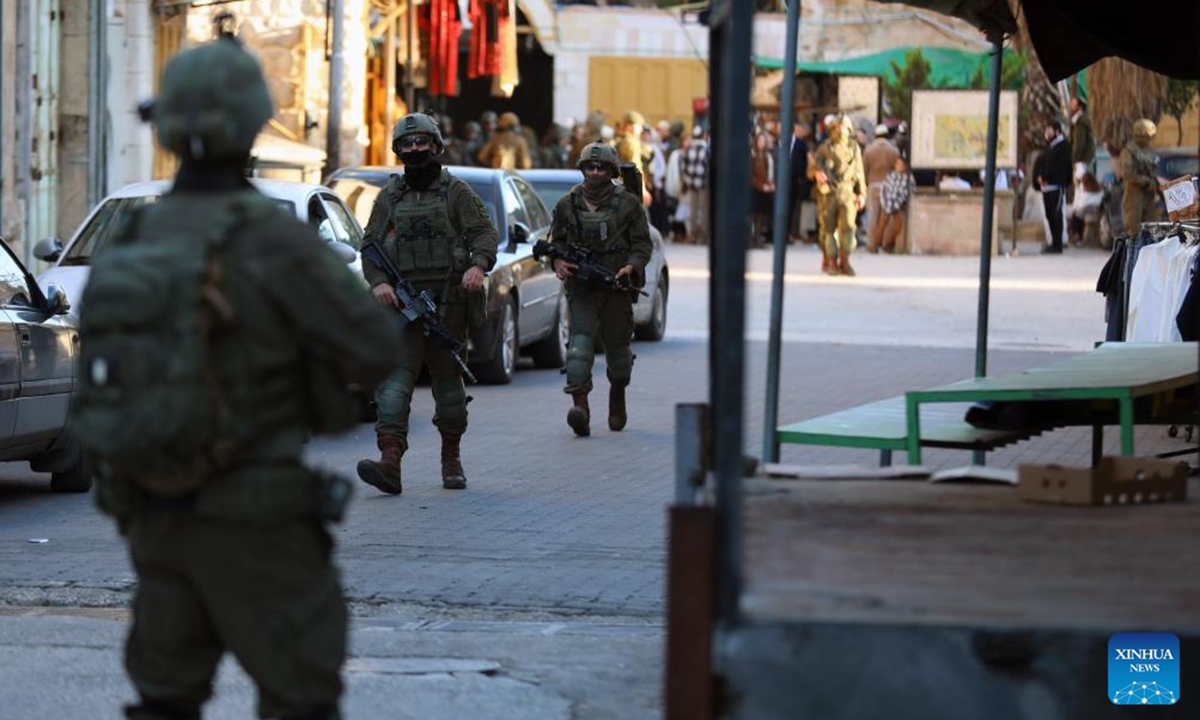 Members of Israeli forces secure the streets for Israeli settlers in the Old City of Hebron in the southern West Bank, on Dec. 20, 2025. (Photo by Mamoun Wazwaz/Xinhua)