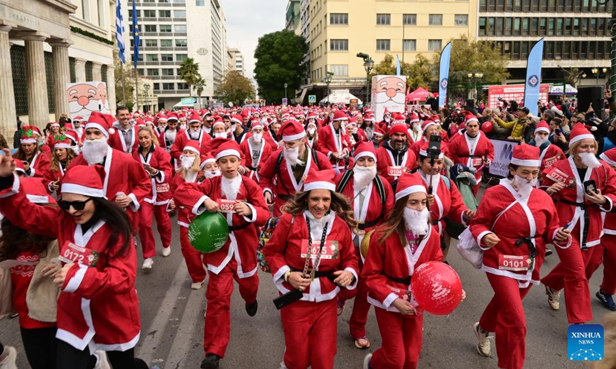 People participate in the Athens Santa Run 2025 in Athens, Greece, Dec. 21, 2025. Thousands of participants dressed as Santa Claus joined the annual Athens Santa Run, a festive and charitable 2.8-km race. (Xinhua/Marios Lolos)