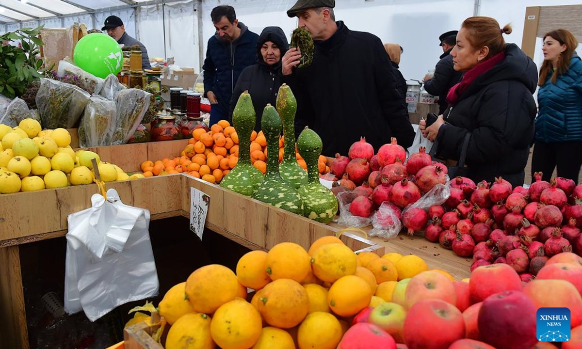 People shop at an agricultural products trade fair in Baku, Azerbaijan, Dec. 21, 2025. With more than 140 specialties from over 80 farms and agricultural product processing enterprises across the country, the trade fair opened here on Saturday, and will run through Dec. 30. (Xinhua/Chen Junfeng)