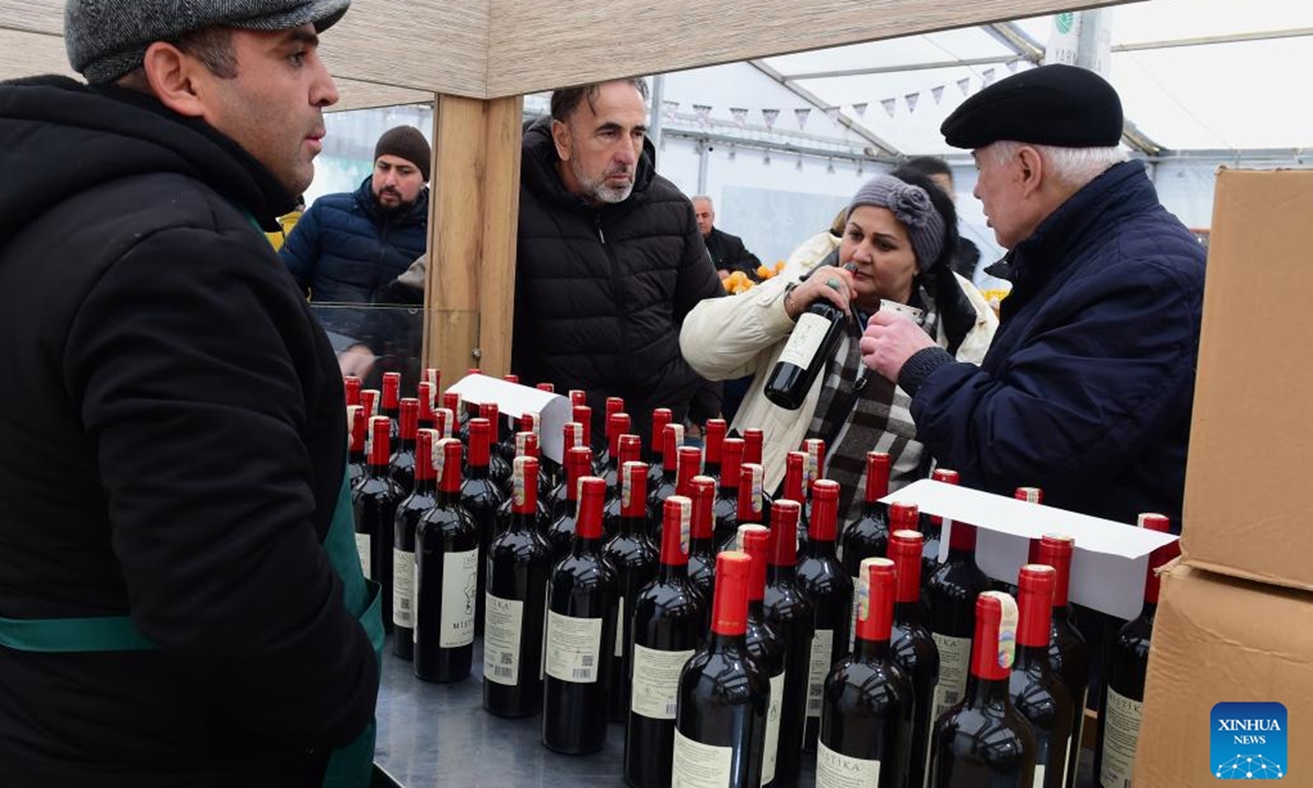 People select honey products at an agricultural products trade fair in Baku, Azerbaijan, Dec. 21, 2025. With more than 140 specialties from over 80 farms and agricultural product processing enterprises across the country, the trade fair opened here on Saturday, and will run through Dec. 30. (Xinhua/Chen Junfeng)