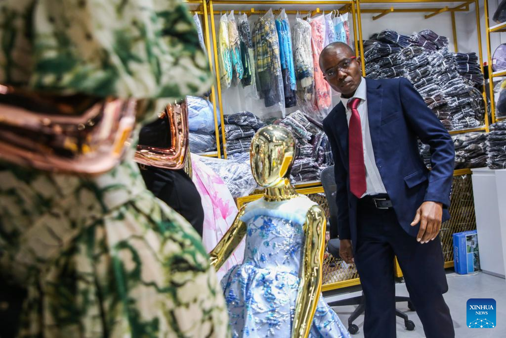 A trader checks clothing displays inside a wholesale showroom at the East Africa Commercial and Logistics Center (EACLC) in Dar es Salaam, Tanzania, Dec. 19, 2025. (Xinhua/Emmanuel Herman)