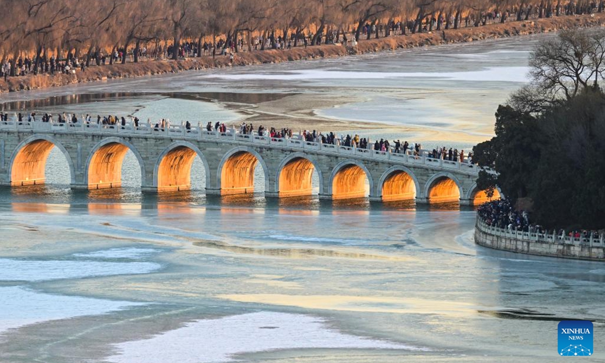 This photo taken on Dec. 21, 2025 shows the Seventeen-Arch Bridge with the sunset glow shining through its arches at the Summer Palace in Beijing, capital of China. (Xinhua/Chen Yehua)