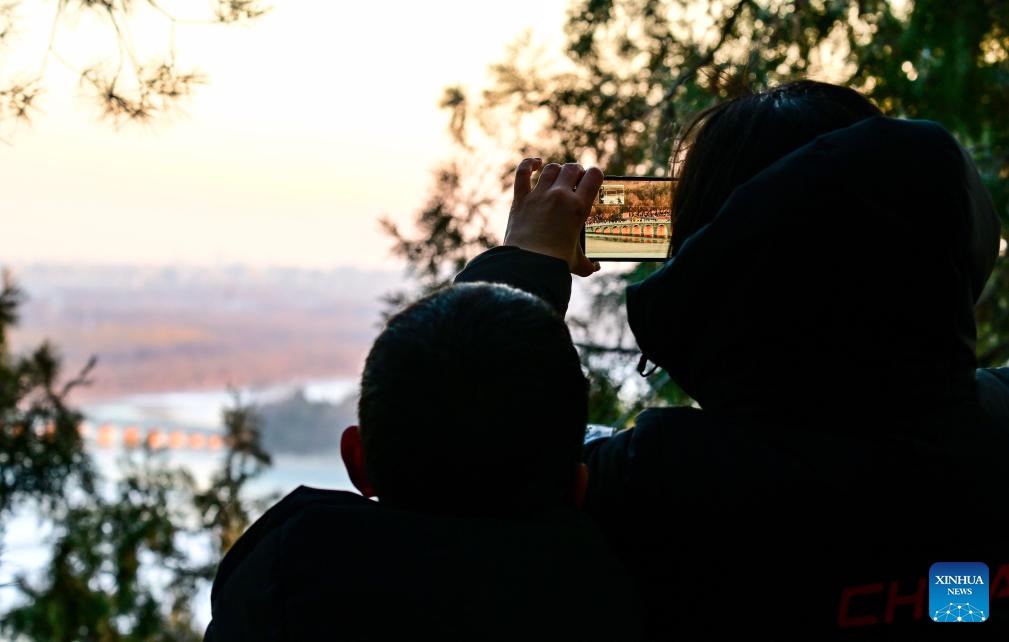 This photo taken on Dec. 21, 2025 shows the Seventeen-Arch Bridge with the sunset glow shining through its arches at the Summer Palace in Beijing, capital of China. (Xinhua/Chen Yehua)
