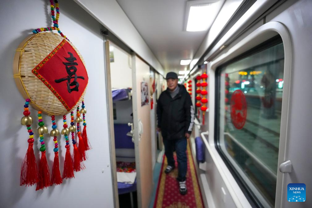 A passenger is seen on Train K7041 at Harbin Railway Station in Harbin, northeast China's Heilongjiang Province, on Dec. 22, 2025. Train K7041, the first northeast folk culture-themed train operated this winter, departed from Harbin Railway Station and headed for Mohe City on Monday. (Xinhua/Wang Song)