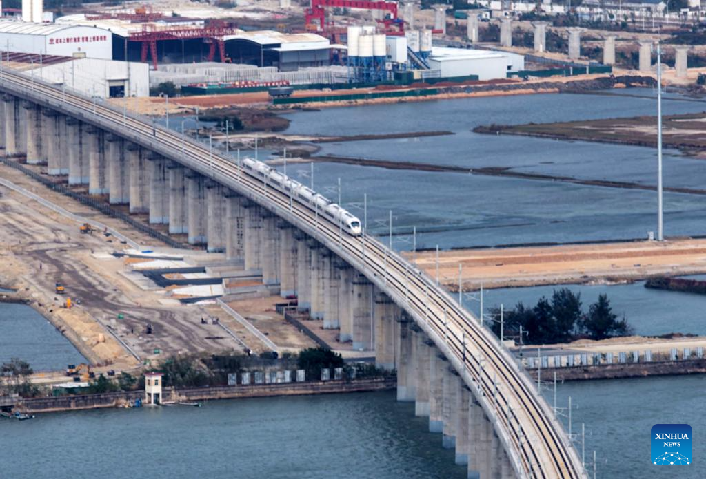 This photo taken on Dec. 22, 2025 shows a high-speed train running on the Haojiang grand bridge in south China's Guangdong Province. The Shantou-Shantou South section of the 162-km-long Shantou-Shanwei high-speed railway was completed and opened to traffic on Monday, marking the full-line operation of the railway. (Photo by Yao Jun/Xinhua)