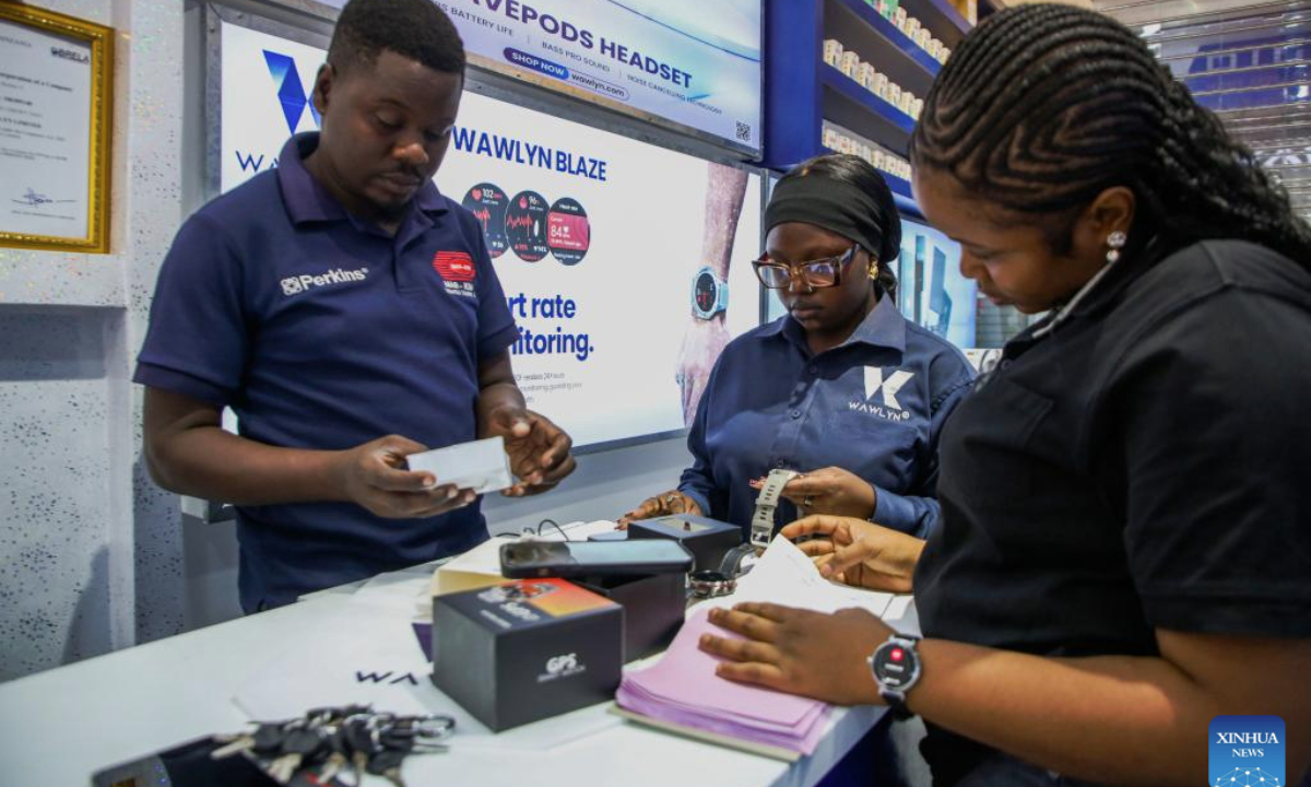 Staff members assist customers at a shop selling electronic products at the East Africa Commercial and Logistics Center (EACLC) in Dar es Salaam, Tanzania, Dec. 19, 2025. (Xinhua/Emmanuel Herman)