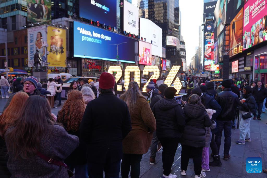 People line up to take photos with a light installation for the upcoming 2026 at Times Square in New York, the United States, Dec. 22, 2025. (Xinhua/Zhang Fengguo)