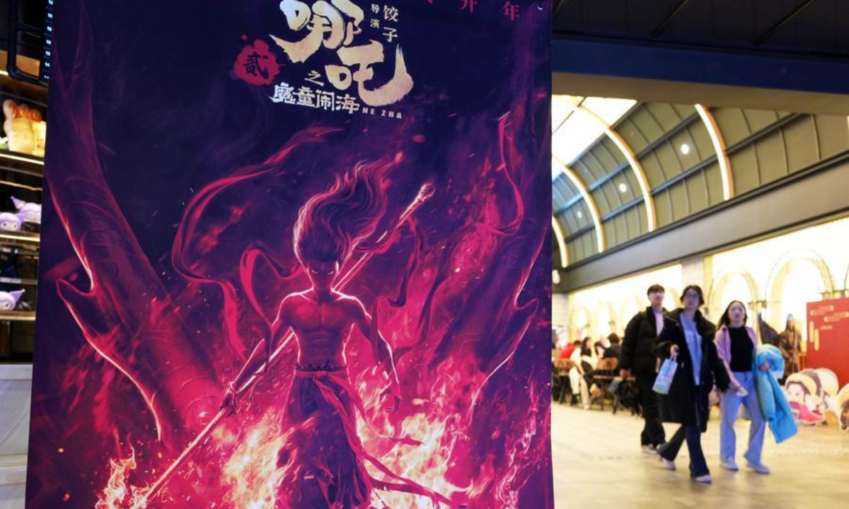People walk past a poster of the animated feature Ne Zha 2 at a cinema in Shenyang, northeast China's Liaoning Province, Feb. 6, 2025. (Xinhua/Li Gang)