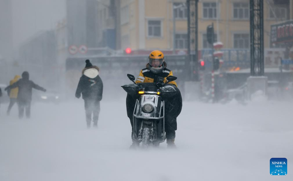A delivery man works in snow in Harbin, northeast China's Heilongjiang Province, Dec. 23, 2025. The meteorological observatory of Harbin issued a yellow alert for blizzard on Tuesday. (Photo by Zhang Shu/Xinhua)