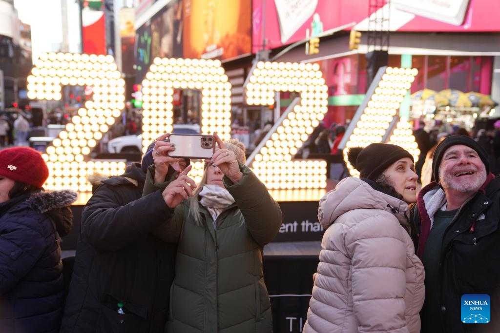 People take selfies in front of a light installation for the upcoming 2026 at Times Square in New York, the United States, Dec. 22, 2025. (Xinhua/Zhang Fengguo)