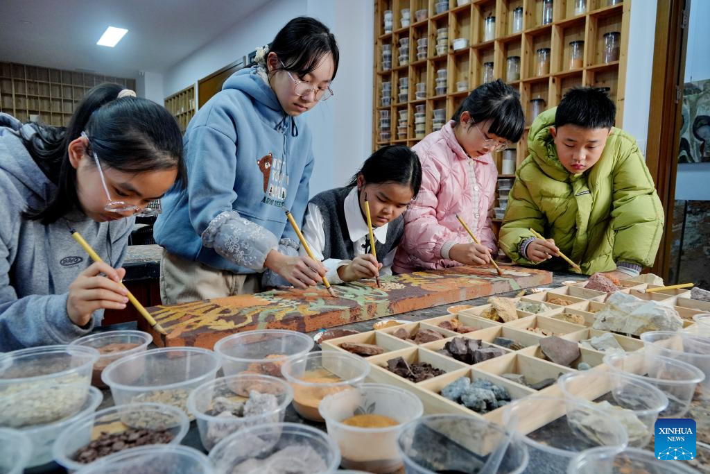 Children work on a piece of rock pigment painting in Wuyishan City, southeast China's Fujian Province, Dec. 20, 2025. Wuyishan boasts a wide range of colorful rock and soil, which serve as a natural palette for painting, giving rise to the distinctive Wuyi rock pigment art. Integrating modern artistic elements and techniques into tradition, Wuyi rock pigment painting is gradually becoming a unique cultural feature of Wuyishan. (Photo by Chen Ying/Xinhua)