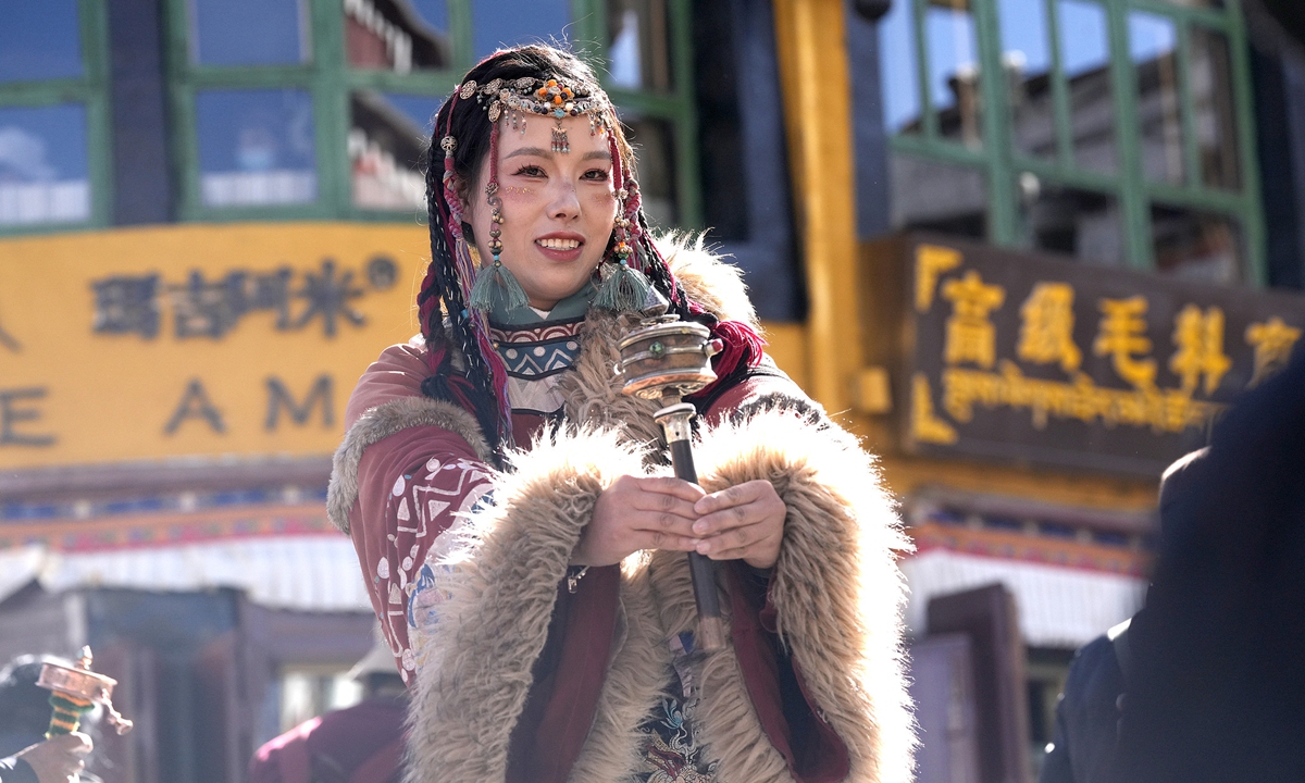 A tourist poses for a photo in traditional Tibetan clothing on Barkhor Street in Lhasa, Southwest China's Xizang Autonomous Region, on December 24, 2025. Driven by an ongoing 