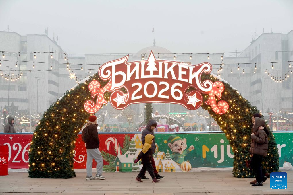 People walk past New Year decorations at the Ala-Too Square in Bishkek, Kyrgyzstan, Dec. 23, 2025. (Photo by Roman/Xinhua)