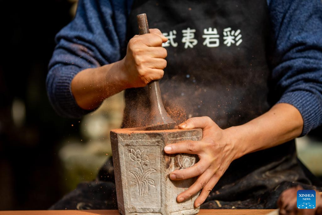 An artist grinds rock and soil into powder in Wuyishan City, southeast China's Fujian Province, Dec. 19, 2025. Wuyishan boasts a wide range of colorful rock and soil, which serve as a natural palette for painting, giving rise to the distinctive Wuyi rock pigment art. Integrating modern artistic elements and techniques into tradition, Wuyi rock pigment painting is gradually becoming a unique cultural feature of Wuyishan. (Photo by Chen Ying/Xinhua)