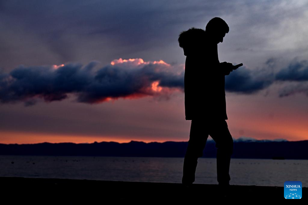 A man walks on Ohrid Lake shore at sunset in Ohrid, Republic of North Macedonia, Dec. 24, 2025. (Photo by Tomislav Georgiev/Xinhua)