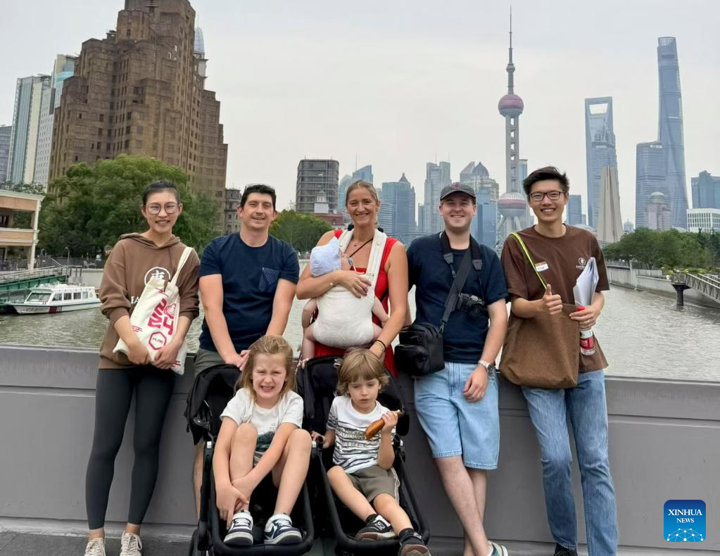Members of Eastbound and Beyond pose for a photo with French tourists in east China's Shanghai in September 2025. (Xinhua)