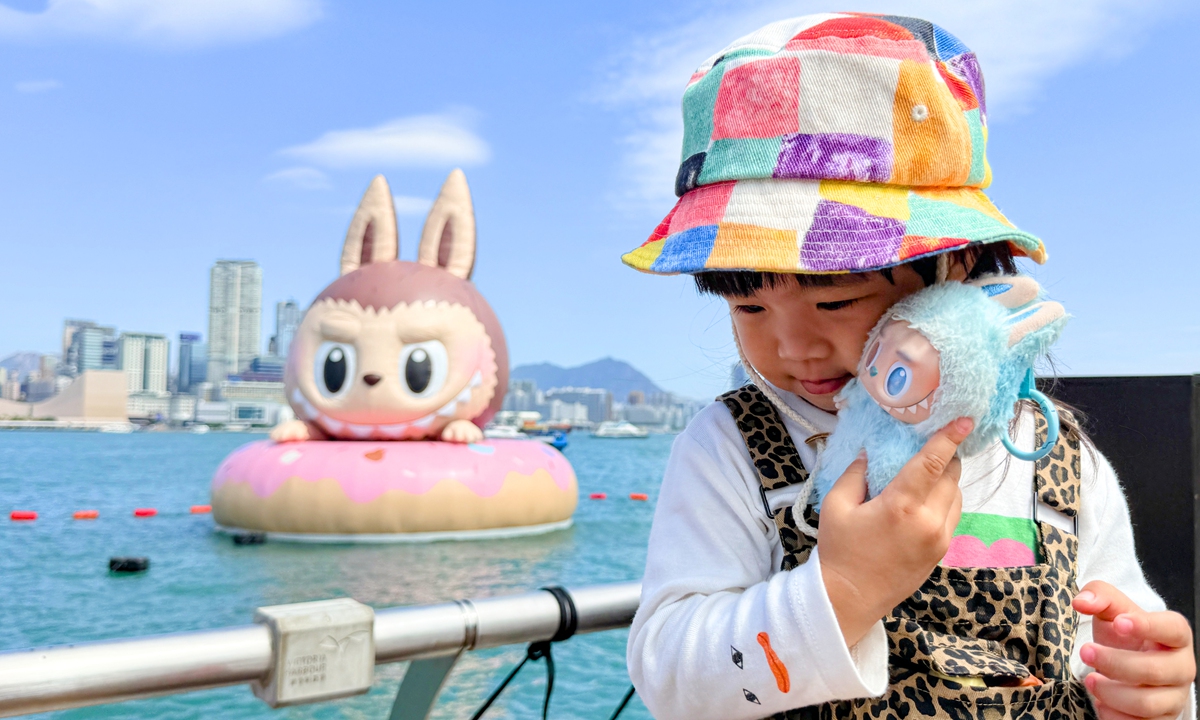 A child holding a doll from POP MART's 