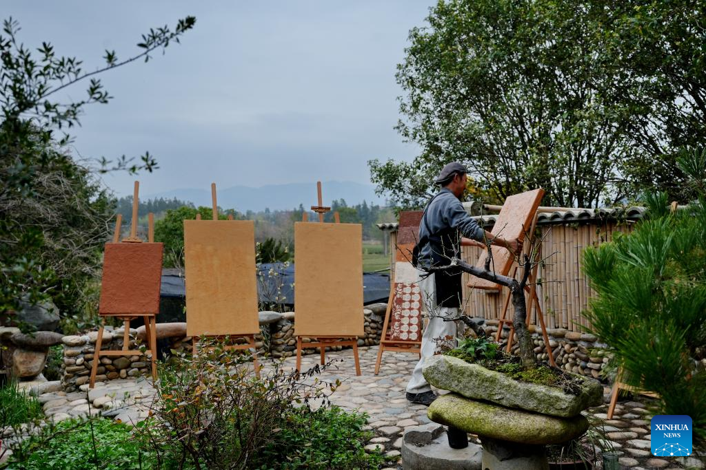 An artist makes boards for rock pigment paintings in Wuyishan City, southeast China's Fujian Province, Dec. 22, 2025. Wuyishan boasts a wide range of colorful rock and soil, which serve as a natural palette for painting, giving rise to the distinctive Wuyi rock pigment art. Integrating modern artistic elements and techniques into tradition, Wuyi rock pigment painting is gradually becoming a unique cultural feature of Wuyishan. (Photo by Chen Ying/Xinhua)