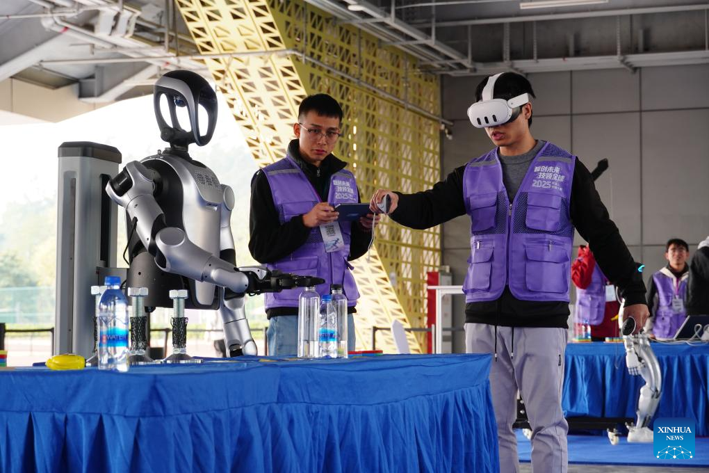 Contestants control a robot during a robot skills competition in Shenzhen, south China's Guangdong Province, Dec. 27, 2025. The robot skills competition kicked off here on Friday and will last till Dec. 30, 2025. Over 100 teams participate in robot application matches ranging from industrial manufacturing, healthcare to emergency rescue scenarios. (Xinhua/Wang Feng)