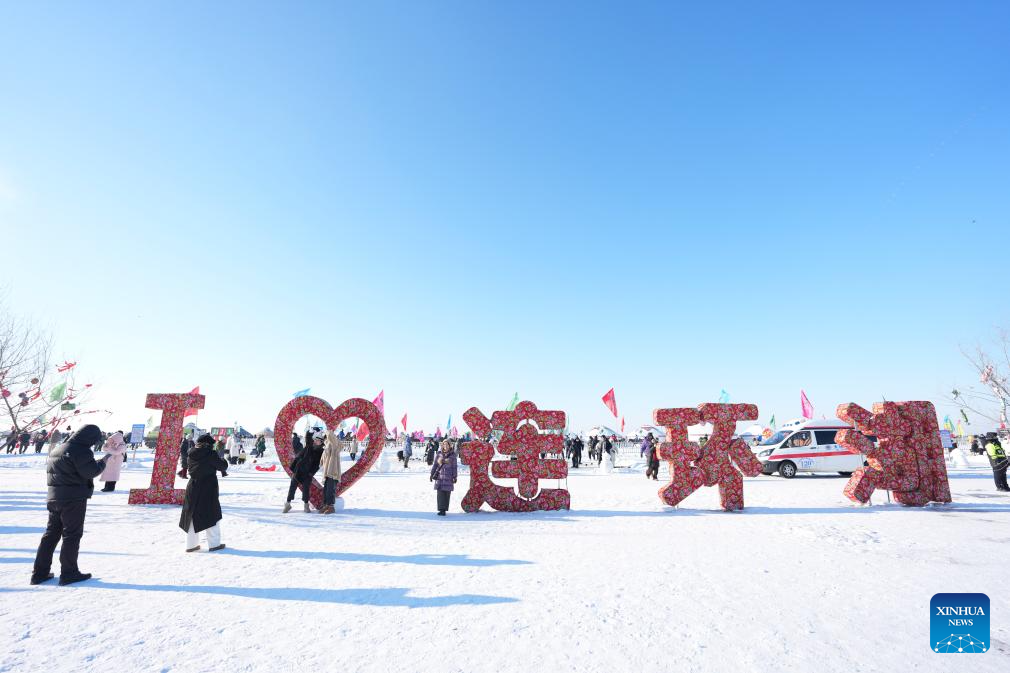 Tourists pose for photos during a winter fishing event of a Nadam fair in Mongolian Autonomous County of Dorbod, Daqing City, northeast China's Heilongjiang Province, Dec. 27, 2025. An ice and snow Nadam fair featuring winter fishing kicked off here on Saturday. The integrated development fishery, and cultural and tourism industry in Dorbod has not only boosted tourism market, but also increased the income of local fishermen. (Xinhua/Wang Song)