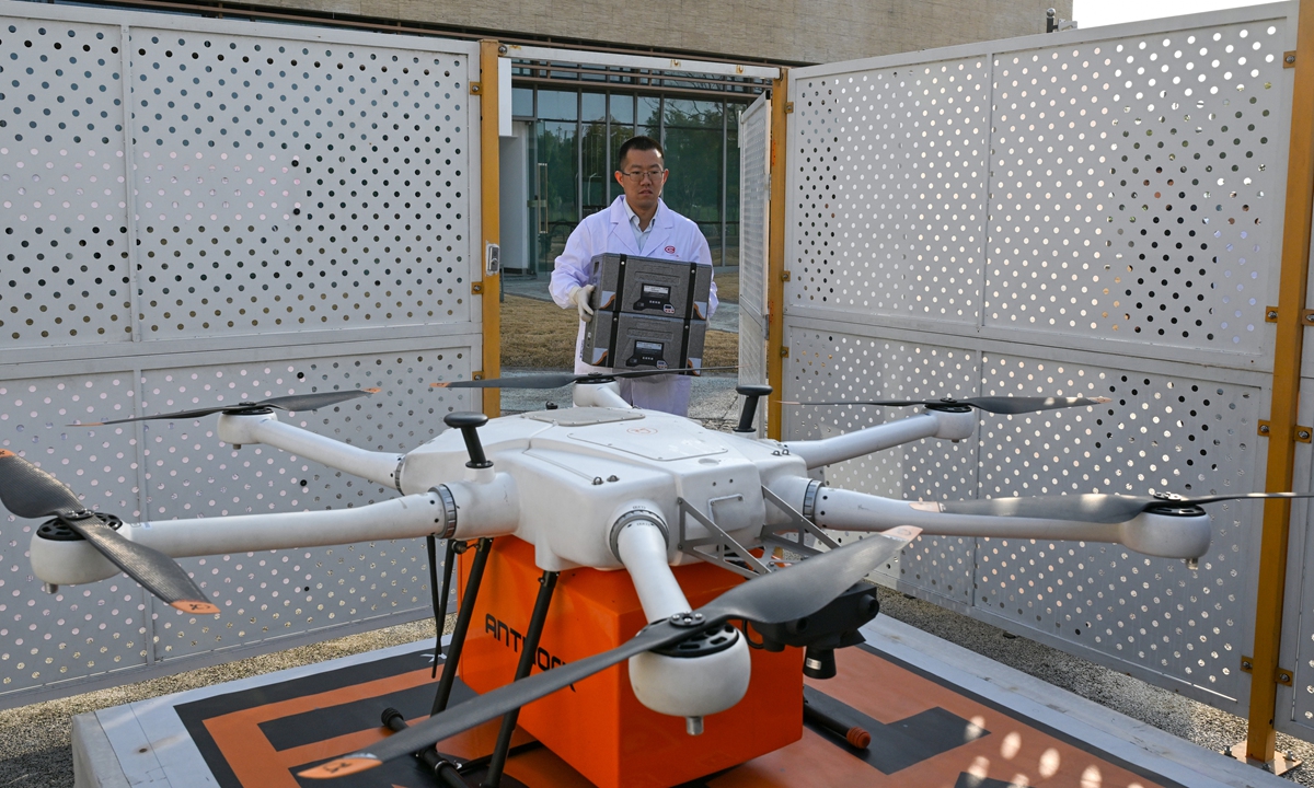 A medical staffer carries a shipment of blood at the city' blood center while a drone successfully completes its maiden flight on a blood delivery mission in Southwest China's Chengdu on December 25, 2025. Compared with traditional ground transportation, the low-altitude drone delivery mode will shorten blood transportation times by more than 50 percent, according to the Xinhua News Agency. Photo: VCG
