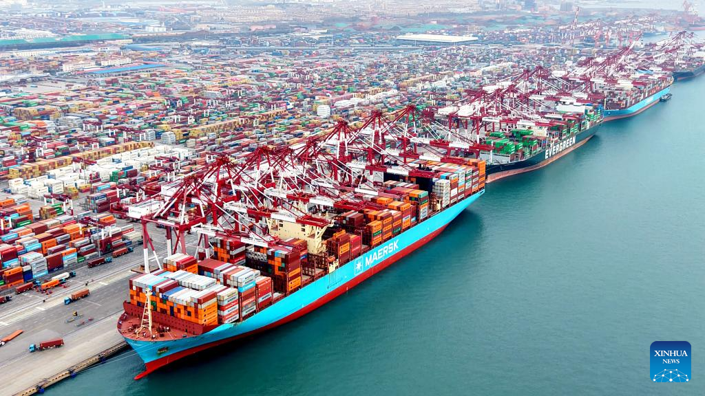 This aerial drone photo taken on Dec. 27, 2025 shows cargo ships loading and unloading containers at Qingdao Port in east China's Shandong Province. Shandong's port cargo throughput this year exceeded 1.9 billion tonnes on Saturday, with container volume surpassing 47 million TEUs. (Photo by Yu Fangping/Xinhua)