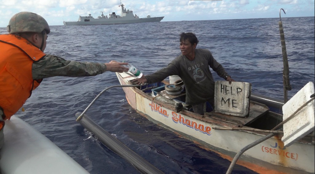 A Chinese PLA navy sailor provides humanitarian assistance to a Philippine fisherman. Photo: Source