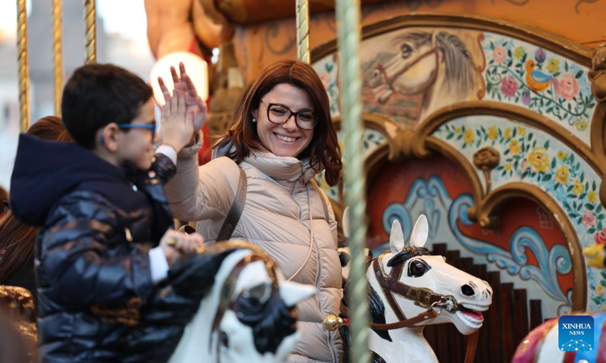 People take rides in a carousel at Piazza Navona in Rome, Italy, Dec. 27, 2025. (Xinhua/Li Jing)