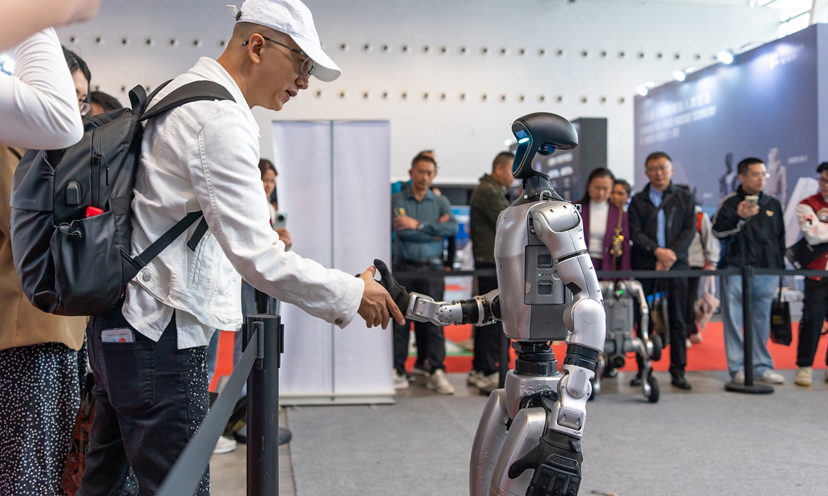 A humanoid robot shakes hands with an attendee at an event in Guangzhou, South China's Guangdong Province on October 22, 2025. Photo: VCG