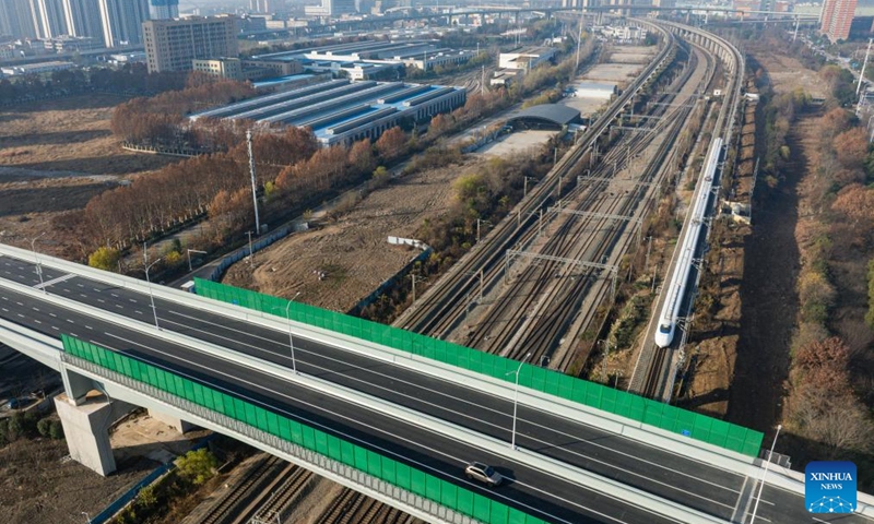 An aerial drone photo shows a bullet train running under the northern section of Gutian First Road in Wuhan, central China's Hubei Province, Dec. 28, 2025. The northern section of Gutian First Road in Wuhan was officially completed and opened to traffic on Sunday. The 2.78-kilometer road, crossing the Shanghai-Chongqing-Chengdu high-speed railway, Wuhan-Danjiangkou Railway, and Wuhan Third Ring Road, will benefit residents along the route. (Xinhua/Wu Zhizun)