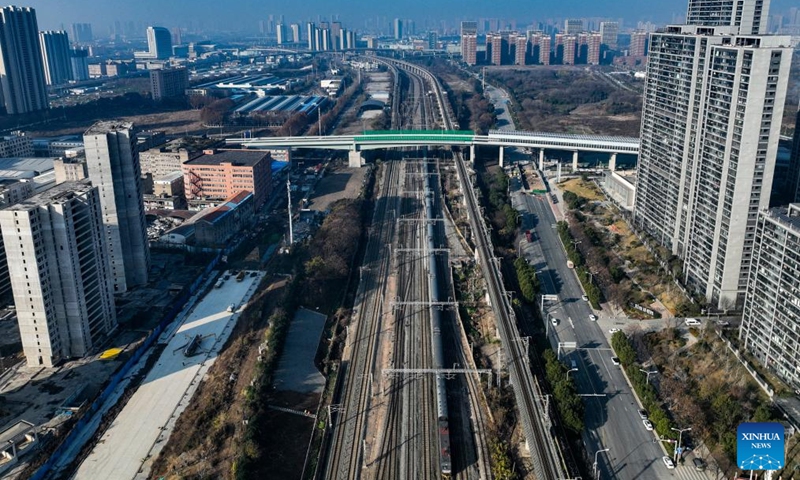 An aerial drone photo shows a bullet train running under the northern section of Gutian First Road in Wuhan, central China's Hubei Province, Dec. 28, 2025. The northern section of Gutian First Road in Wuhan was officially completed and opened to traffic on Sunday. The 2.78-kilometer road, crossing the Shanghai-Chongqing-Chengdu high-speed railway, Wuhan-Danjiangkou Railway, and Wuhan Third Ring Road, will benefit residents along the route. (Xinhua/Wu Zhizun)