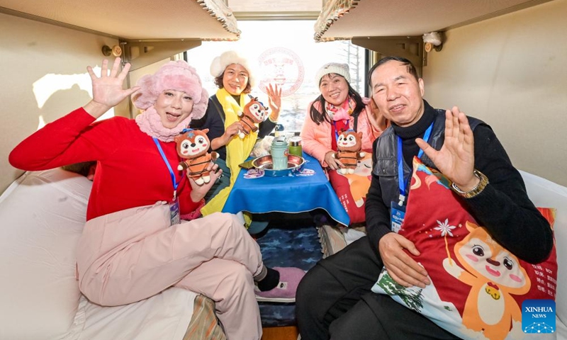 Tourists pose for photos onboard a tourism train in northeast China's Heilongjiang Province, on Dec. 28, 2025. Train Y999/998, an ice-and-snow themed tourism loop train, started a six-day trip on Sunday. (Photo by Yuan Yong/Xinhua)