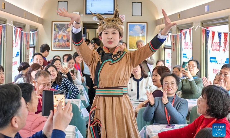 Tourists watch a performance onboard a tourism train in northeast China's Heilongjiang Province, on Dec. 28, 2025. Train Y999/998, an ice-and-snow themed tourism loop train, started a six-day trip on Sunday. (Photo by Yuan Yong/Xinhua)